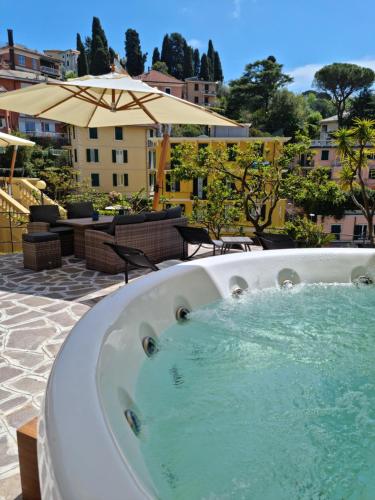 拉帕洛Hotel Canali, Portofino Coast的庭院内的按摩浴缸和遮阳伞
