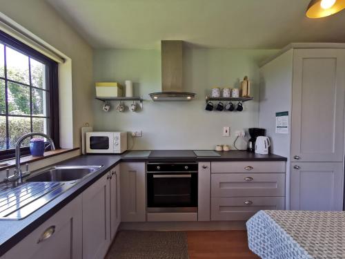 海上费萨德Ban Milis 1的厨房配有水槽和炉灶 顶部烤箱