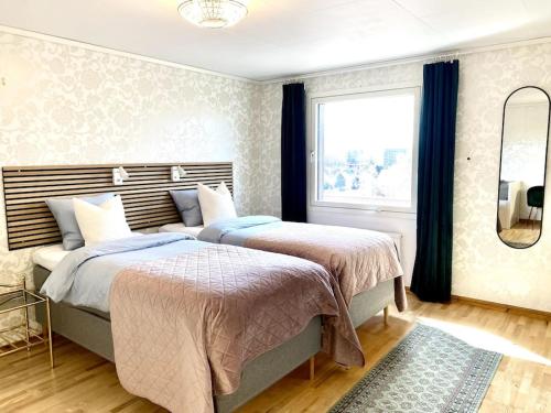 哥德堡Apartment Aekta Studio 4 Gothenburg的一间卧室设有两张床和窗户。