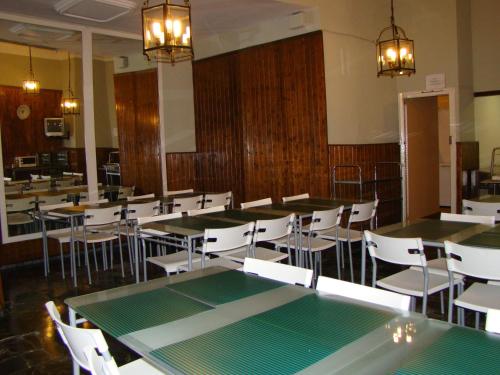 马拉加圣保拉旅馆的用餐室配有桌子和白色椅子