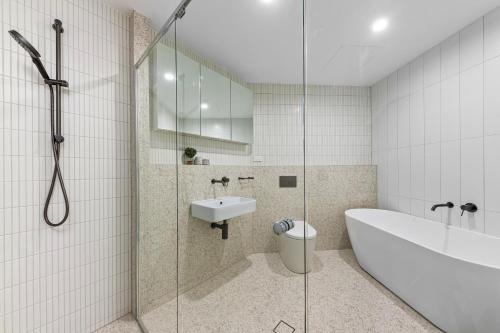 悉尼Elegant and Modern Style Apartments in Dulwich hill的带浴缸、水槽和淋浴的浴室