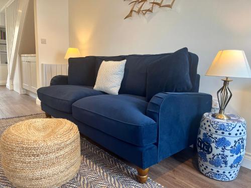 米德尔赫姆Wesley Cottage的客厅里设有蓝色的沙发,配有灯