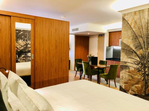阿姆斯特丹Chassé Hotel Residency的酒店客房带一张床、一张桌子和椅子