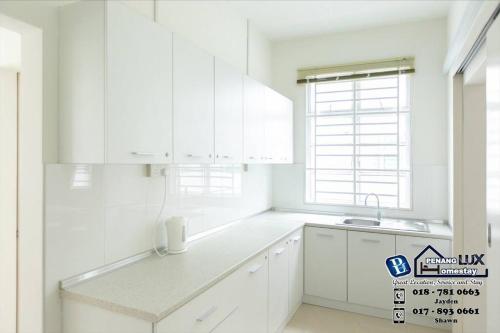 浮罗山背Balik Pulau 6BR Comfort Home Villa的白色的厨房配有白色橱柜和水槽