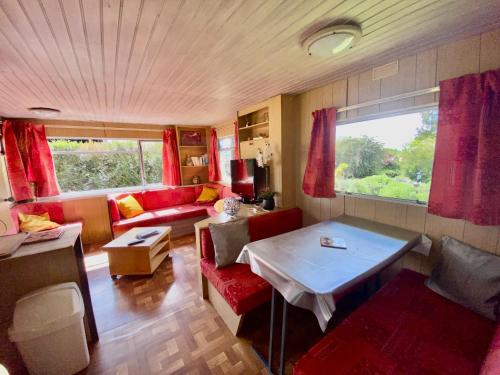 JosnesMobilhome sous chalet en bois au calme à la ferme的客厅配有红色的沙发和桌子