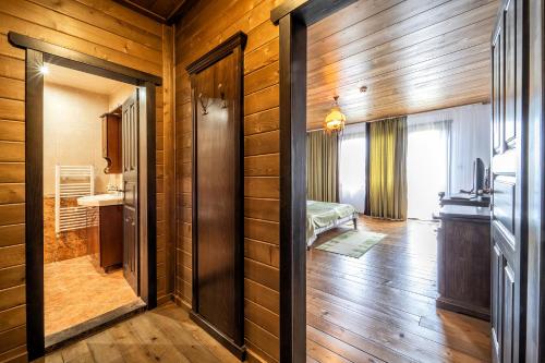 杜瑞古拉克Hotel Complex Zlatnata Ribka的一间设有木墙的客房和一个带卧室的走廊