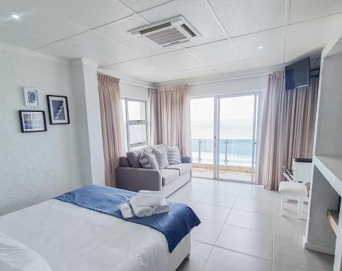 莫塞尔湾Diaz Ocean View Hotel的一间卧室配有一张床,客厅配有沙发