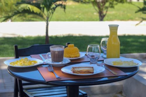 巴纳伊巴Pousada Primavera的餐桌,带食物盘和一瓶橙汁