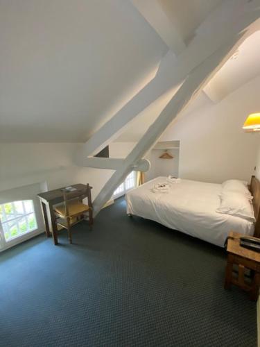 罗科比列尔HOTEL ST SEBASTIEN的一间卧室配有一张床、一张书桌和一个楼梯