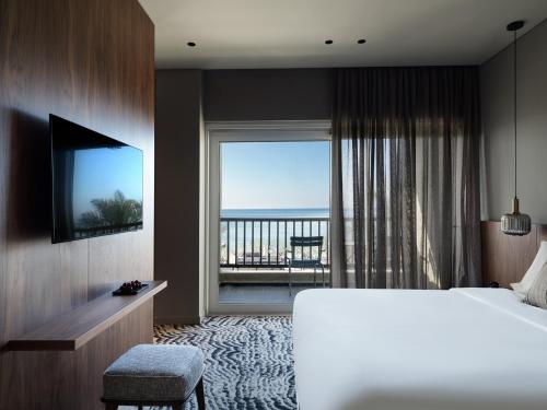 毕达哥利翁德里萨海滨度假酒店的酒店客房设有一张床和一个大窗户