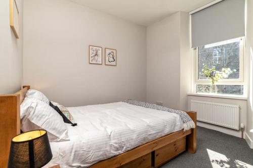 阿伯丁West End @ Netflix @ Newly Built的一间卧室配有一张带白色床单的床和一扇窗户。