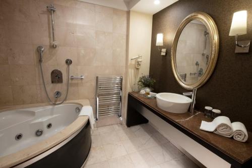伊斯坦布尔Agaoğlu My City Hotel Istanbul的带浴缸、水槽和镜子的浴室