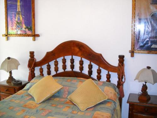 蒙特格兰德Hotel Aeropuerto Monte Grande的一间卧室配有木床和2个床头柜