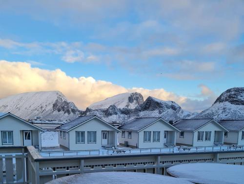 VærøyLofoten Værøy Bryggehotell AS的雪 ⁇ 的山前一排房子