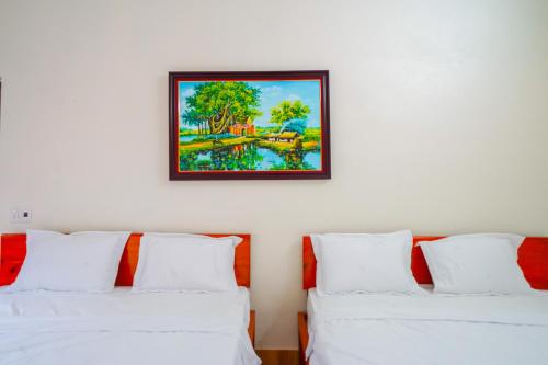 峰牙Phong Nha Magic Fingers Homestay and Spa的墙上有两张白色的床