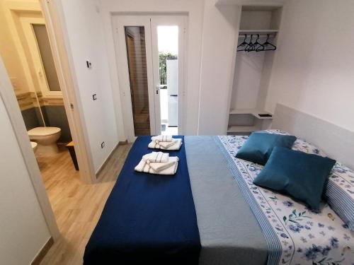 福尔米亚Parco dei Gerani的一间卧室配有蓝色的床和毛巾