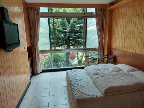 平溪十分幸福民宿的一间卧室设有一张床和一个大窗户