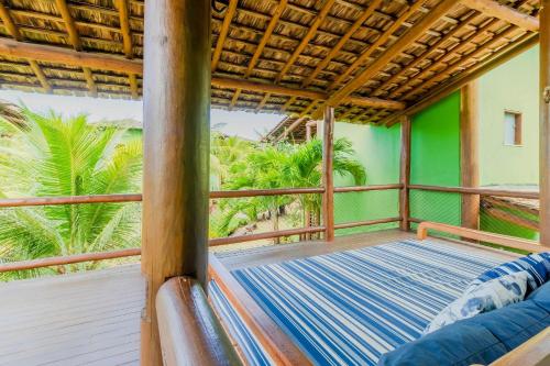 伊塔齐米林IT70 Ótimo Bangalô Duplex Beira Mar的一个带床和棕榈树的阳台
