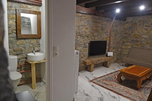 VathýThe Stonewall House - at the old town of Samos的一间带水槽和卫生间的浴室以及一台电视。