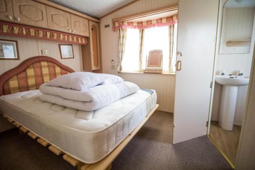 亨斯坦顿6 Berth Caravan In Hunstanton, Ideal For Seaside Holidays Ref 13004l的一间卧室设有床、窗户和水槽