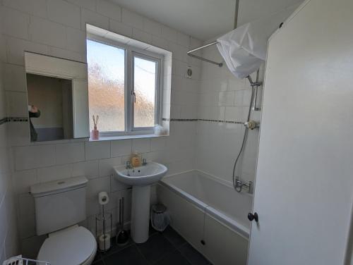 布里斯托5 bed terraced family home Bristol + parking的浴室配有卫生间、盥洗盆和浴缸。