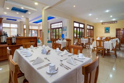 阿约拉港拉古纳别墅酒店酒店的用餐室配有带白色桌布的桌子