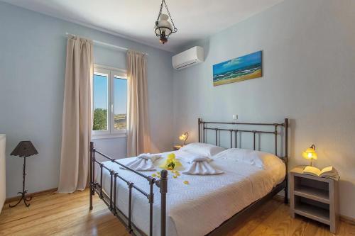 纳乌萨SAIL VILLA的一间卧室配有一张带白色床单的床和一扇窗户。