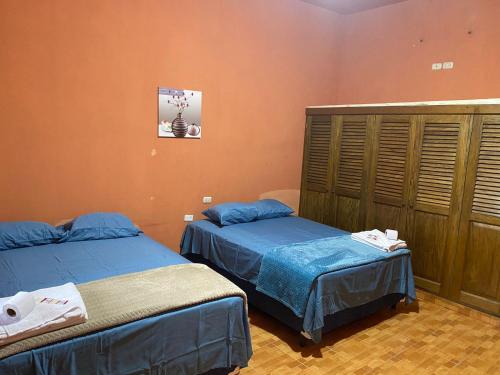 危地马拉Ciudad Vieja Bed & Breakfast Hotel的橙色墙壁客房的两张床