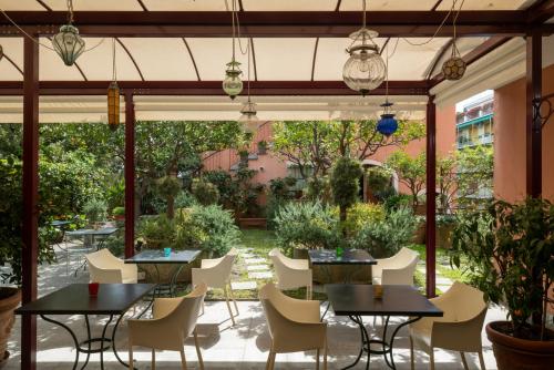 圣玛格丽塔-利古雷密涅瓦酒店的一个带桌椅的庭院和一个花园