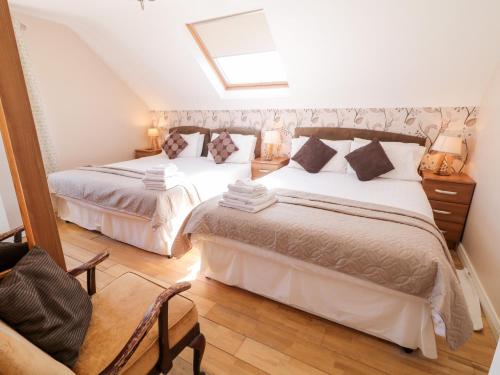 道宁斯Inverbeg Cottage 2的一间卧室设有两张床和天窗