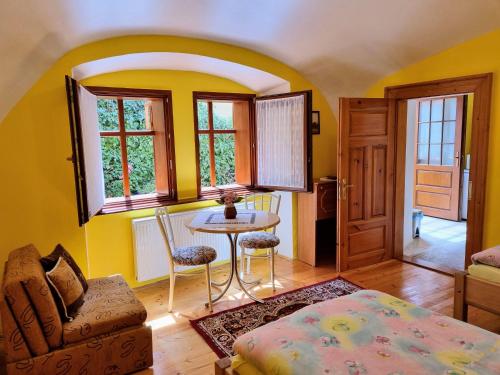 莱沃恰Historical house in the center Levoča with parking的客厅设有黄色的墙壁和桌椅
