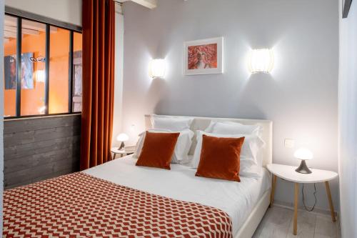 安锡FITZ ROY Annecy Rent Lodge的一间卧室配有带橙色和白色枕头的床