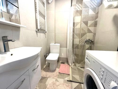 普里什蒂纳黄屋公寓的浴室配有卫生间、盥洗盆和淋浴。