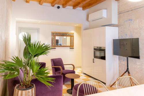 博洛尼亚Palazzo Scappi Gardi Luxury Apartments的客厅配有紫色椅子和电视