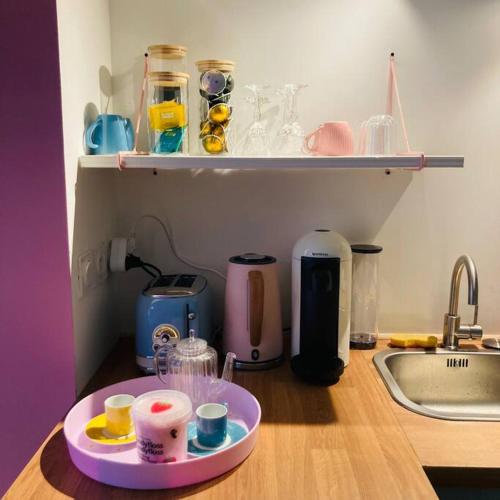 鲁昂Barbapappart - Un studio coloré dans le centre de Rouen的厨房柜台,盘子上装有杯子