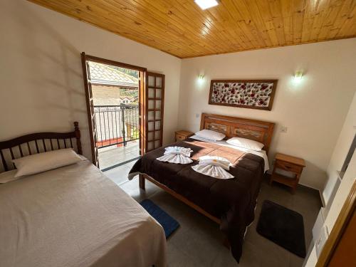 蒙特韦尔迪Pousada Requinte da Serra的带窗户的客房内的两张床