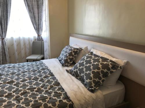 内罗毕Maliaways Comfy Airbnb-Jkia的卧室配有带枕头的床铺和窗户。