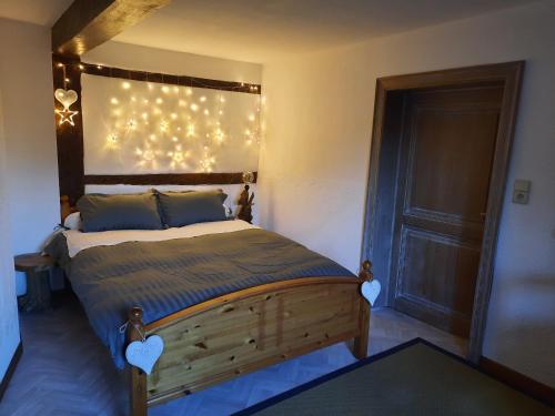 斯塔沃洛Le Têli du loup的卧室配有一张挂在墙上的灯光床。
