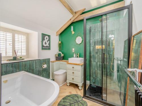 AytonLow Hall Barn的绿色浴室设有浴缸和淋浴。