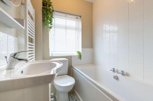 诺里奇Corner Cottage的浴室配有卫生间、盥洗盆和浴缸。