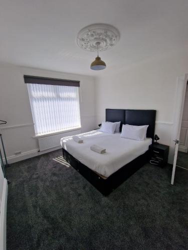 盖茨黑德Luna Apartments Newcastle Gateshead 1的一间卧室配有一张带白色床单的大床
