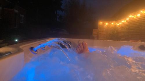 沃明翰Fantastic Location, Annexe with Hot Tub的一个人在晚上躺在浴缸里