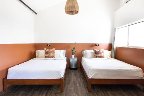 Del NorteMellow Moon Lodge的橙色墙壁客房的两张床