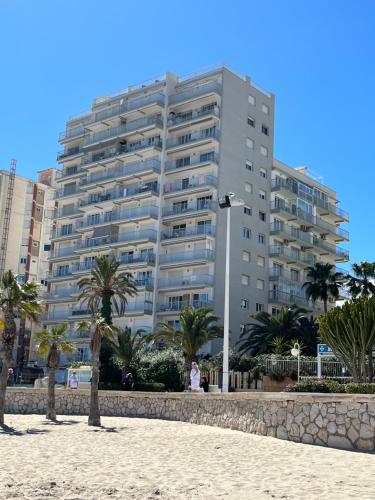卡尔佩Duplex Penthouse的棕榈树海滩上的大型公寓楼