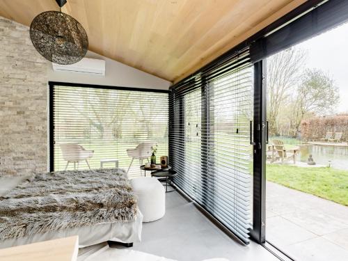 KampenhoutBulsomhuys的卧室设有大窗户和一张床,享有水景