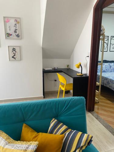 阿拉沙Wabisabi Residence的一间带蓝色沙发的客厅和一间卧室