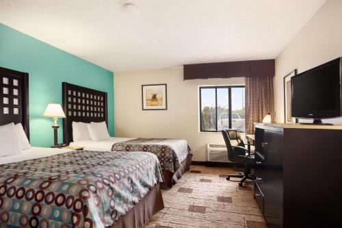 史密斯堡Days Inn by Wyndham Fort Smith的酒店客房设有两张床和一台平面电视。