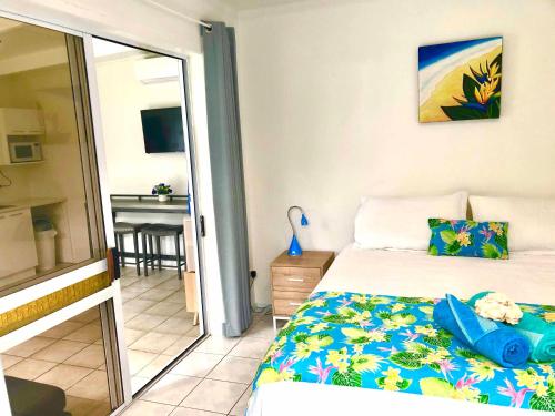 阿瓦鲁阿Avarua Escape, Rarotonga的一间卧室配有一张床,阳台配有桌子