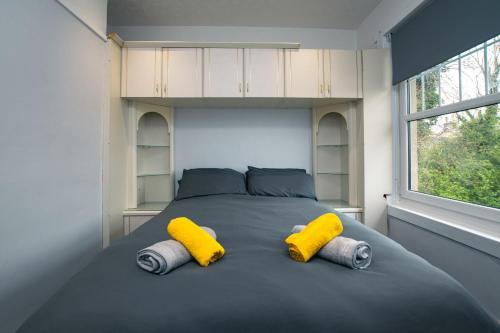 米尔盖Cosy & Central 2BD Apartment Milngavie, Glasgow的一间卧室配有一张大床和两张黄色枕头
