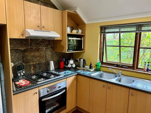库马库马伍德维尔度假屋的厨房配有炉灶和水槽